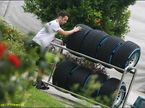 Механик Mercedes везет тележку с шинами в паддоке Гран При Малайзии