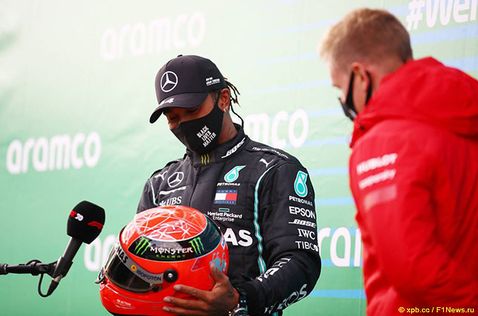 Льюис Хэмилтон принимает от Мика Шумахера шлем, в котором семикраный чемпион мира выступал за Mercedes в 2021 году